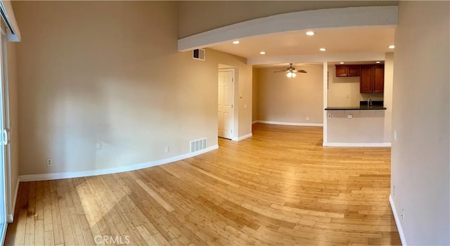 unfurnished living room with ceiling fan and light hardwood / wood-style flooring