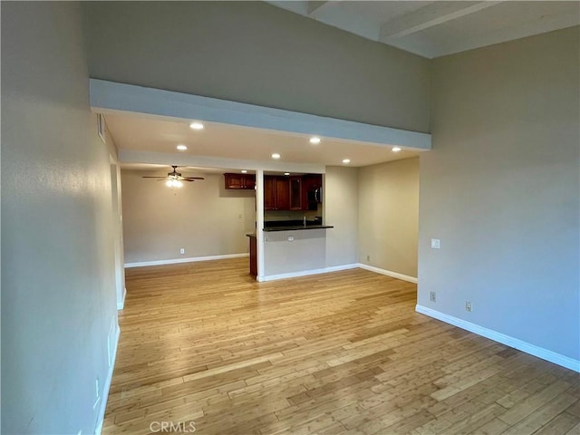 unfurnished living room with ceiling fan and light wood-type flooring