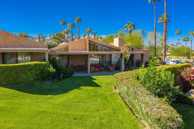 rear view of property featuring a patio area and a yard