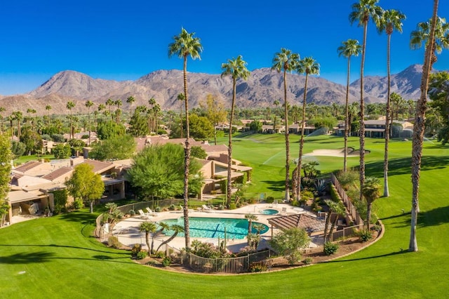 view of swimming pool with a mountain view and a yard