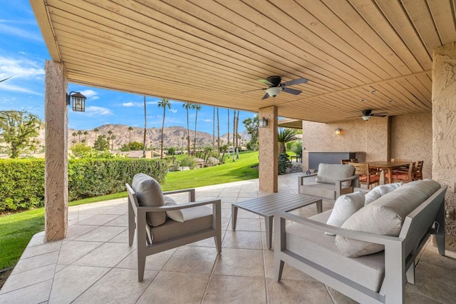 view of patio with outdoor lounge area, a mountain view, and ceiling fan