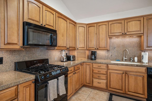 kitchen featuring sink, tasteful backsplash, vaulted ceiling, light tile patterned floors, and black appliances