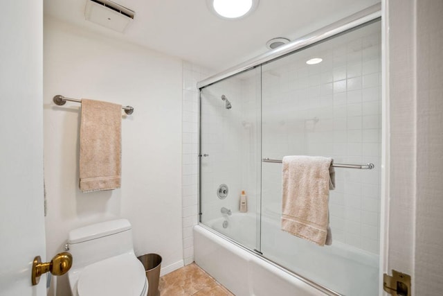 bathroom with tile patterned flooring, enclosed tub / shower combo, and toilet