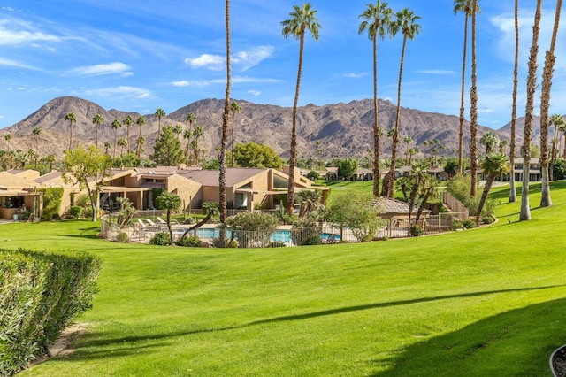 exterior space with a mountain view, a yard, and a swimming pool