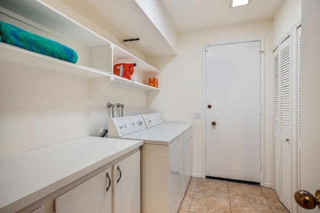 clothes washing area with washer and dryer and light tile patterned floors