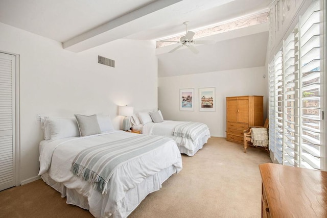 carpeted bedroom with beamed ceiling and ceiling fan