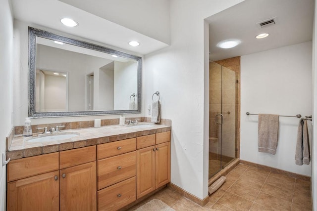 bathroom with tile patterned floors, a shower with door, and vanity