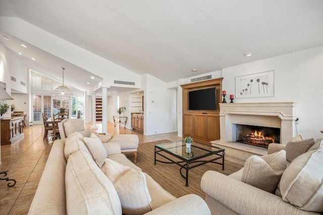 tiled living room featuring ornate columns and lofted ceiling