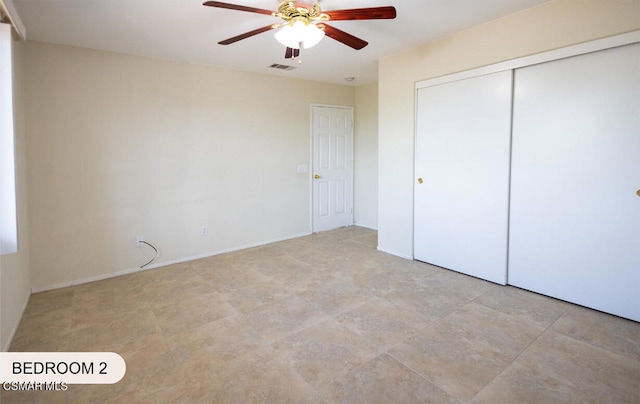 unfurnished bedroom featuring ceiling fan and a closet