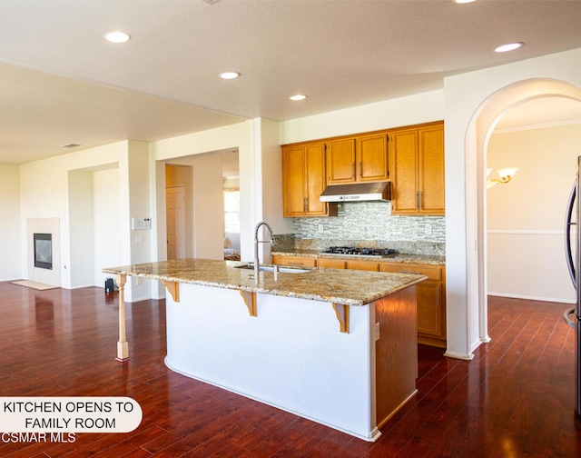 kitchen featuring stainless steel gas cooktop, dark hardwood / wood-style flooring, a center island with sink, and sink