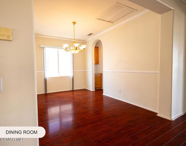 unfurnished room with dark hardwood / wood-style floors, ornamental molding, and an inviting chandelier