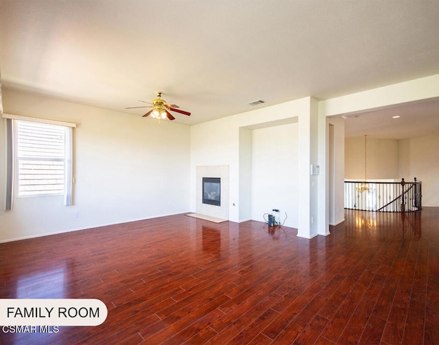 unfurnished living room with ceiling fan and dark wood-type flooring