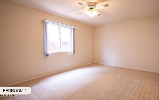 carpeted spare room with ceiling fan