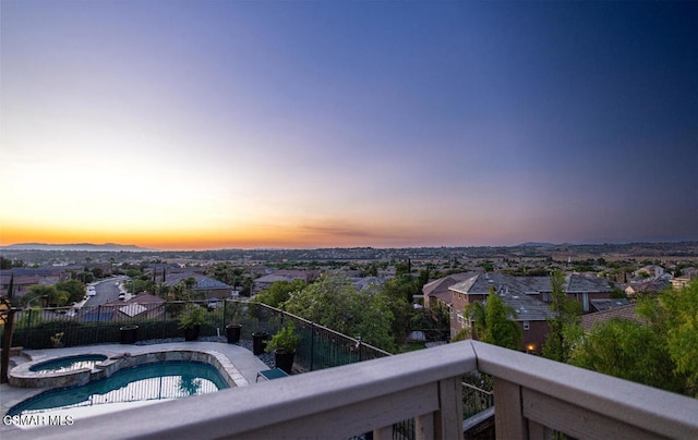 pool at dusk with an in ground hot tub