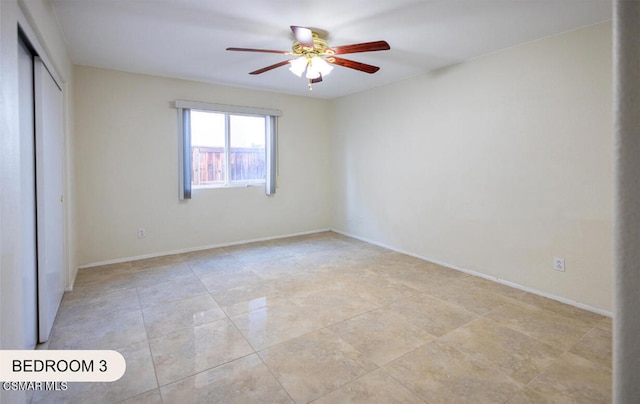 unfurnished bedroom featuring ceiling fan and a closet