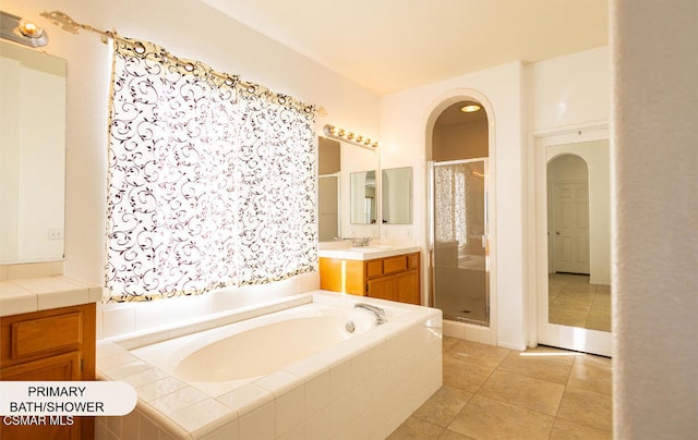 bathroom with tile patterned flooring, vanity, and separate shower and tub