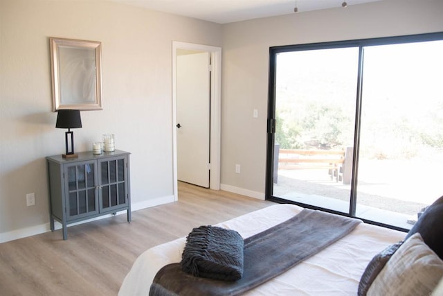 bedroom with access to exterior and light hardwood / wood-style floors