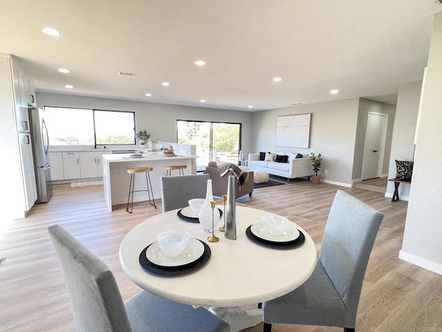 dining space with a wealth of natural light and light hardwood / wood-style flooring