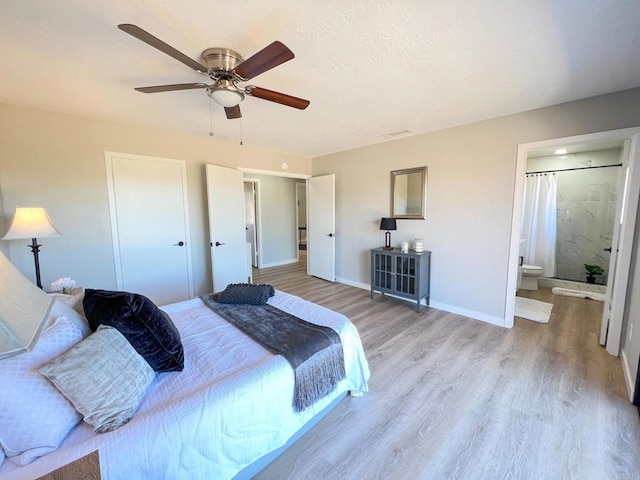 bedroom featuring a closet, ceiling fan, light hardwood / wood-style floors, and ensuite bath