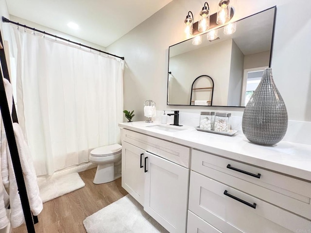 full bathroom featuring vanity, hardwood / wood-style floors, shower / tub combo, and toilet