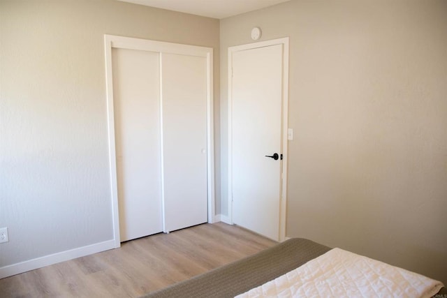 unfurnished bedroom featuring light wood-type flooring and a closet