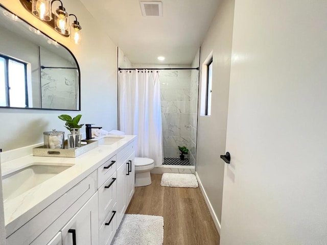 bathroom with a shower with shower curtain, vanity, toilet, and hardwood / wood-style floors