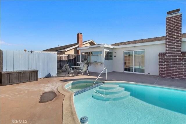 view of pool featuring a patio area and an in ground hot tub