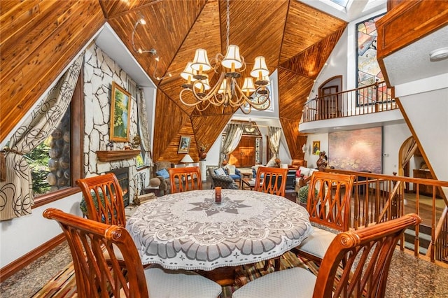 dining room featuring a chandelier, high vaulted ceiling, a stone fireplace, and wooden ceiling