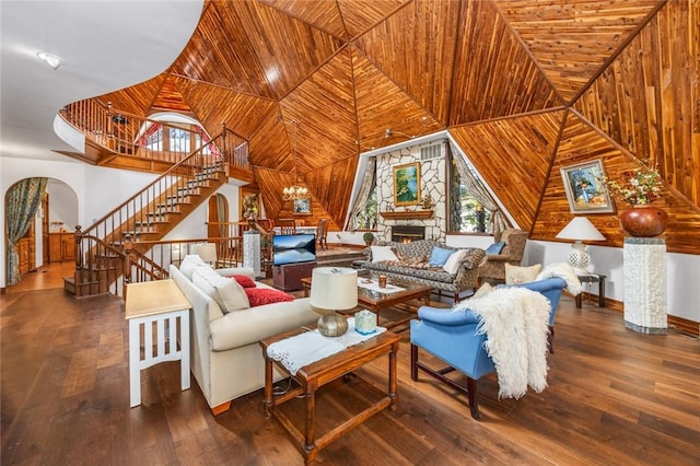 living room featuring hardwood / wood-style flooring, a stone fireplace, wooden ceiling, and an inviting chandelier