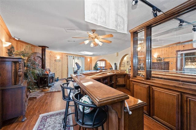 160 Yosemite Dr, Big Bear City, CA 92314 - bar with wooden walls, a wood stove, dark wood-style flooring, and a ceiling fan