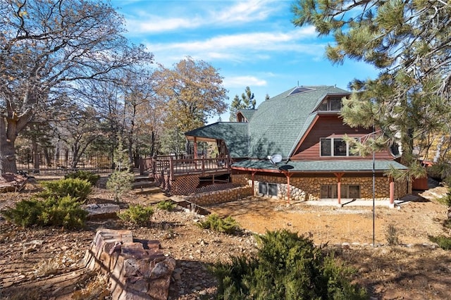 160 Yosemite Dr, Big Bear City, CA 92314 - back of property with a wooden deck, stone siding, and a shingled roof