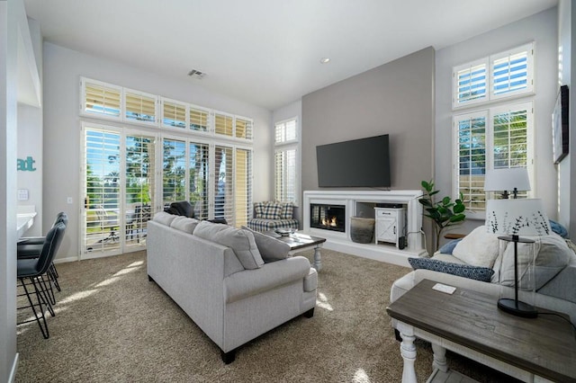 carpeted living room featuring a towering ceiling