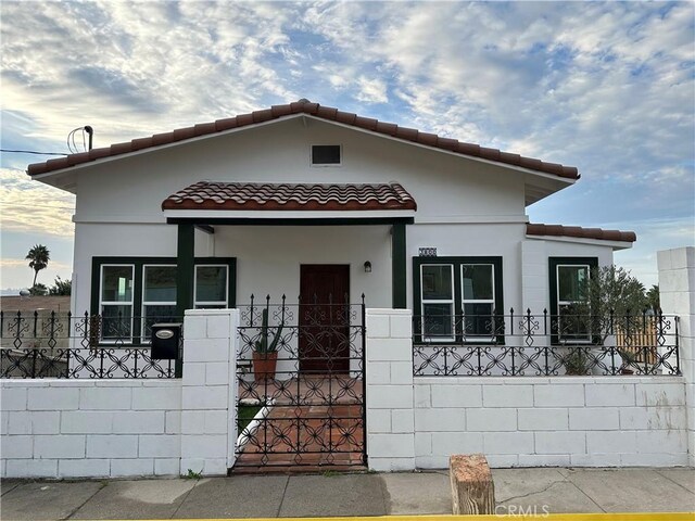 mediterranean / spanish home featuring covered porch