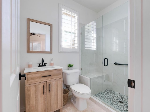 bathroom featuring tile patterned flooring, a shower with door, vanity, and toilet