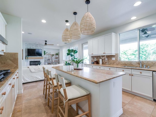 kitchen featuring tasteful backsplash, a wealth of natural light, white cabinetry, and hanging light fixtures