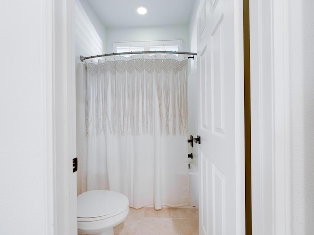 bathroom with tile patterned flooring, toilet, and shower / bath combo with shower curtain