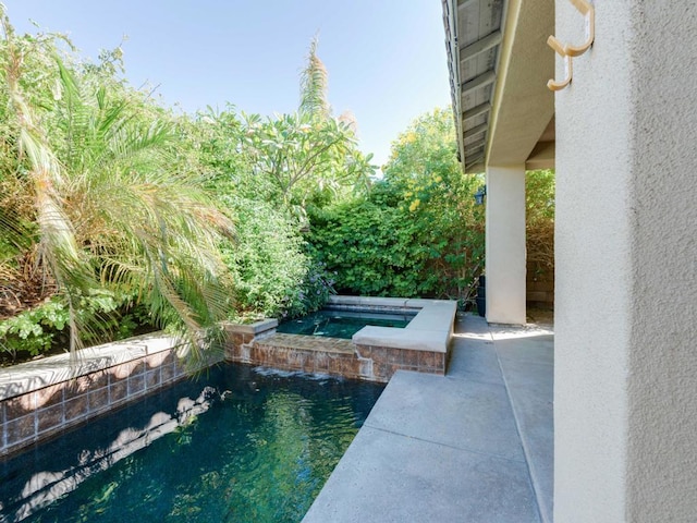 view of swimming pool with an in ground hot tub