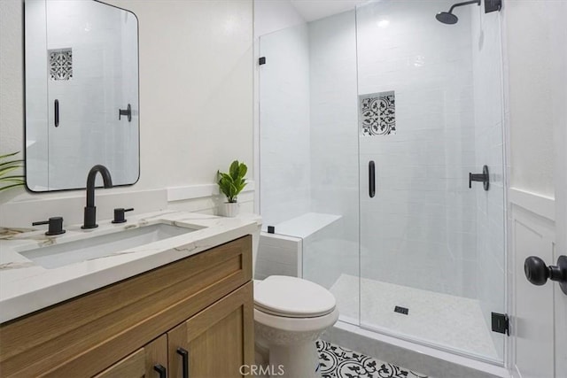 bathroom with vanity, toilet, and a shower with shower door