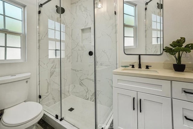 bathroom with vanity, toilet, and a shower with door