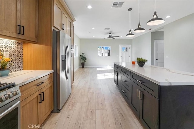 kitchen featuring ceiling fan, stainless steel appliances, light hardwood / wood-style flooring, a spacious island, and pendant lighting