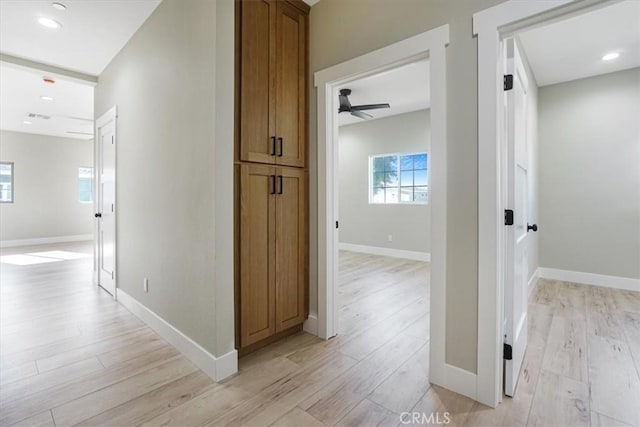 hallway with light hardwood / wood-style floors