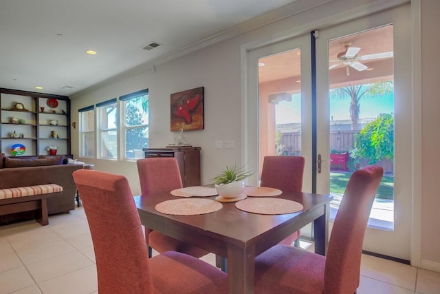 tiled dining room with ceiling fan and ornamental molding