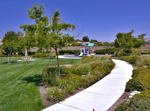 view of home's community featuring a playground and a yard