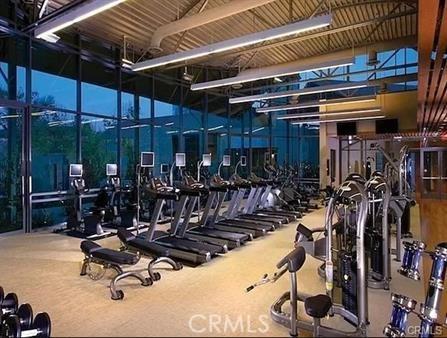 workout area featuring a towering ceiling and carpet flooring