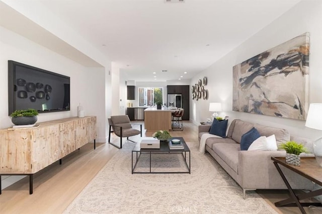 living area featuring recessed lighting, visible vents, and light wood-style flooring