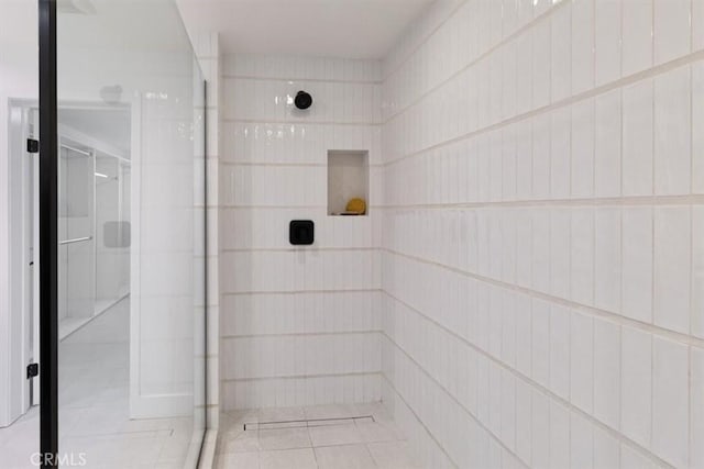 bathroom with tiled shower and tile patterned floors