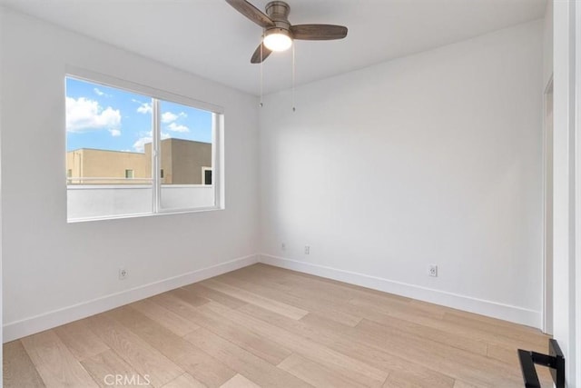 empty room featuring ceiling fan, light wood-type flooring, and baseboards