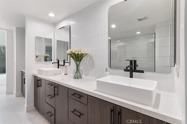 bathroom with double vanity, walk in shower, tile patterned flooring, and a sink