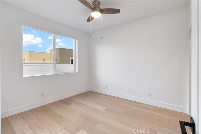 unfurnished room featuring light wood-style floors, baseboards, and a ceiling fan