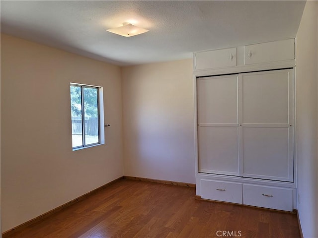 unfurnished bedroom featuring wood-type flooring and a closet